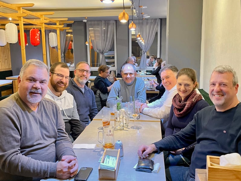 Seven people sit around a table at a restaurant