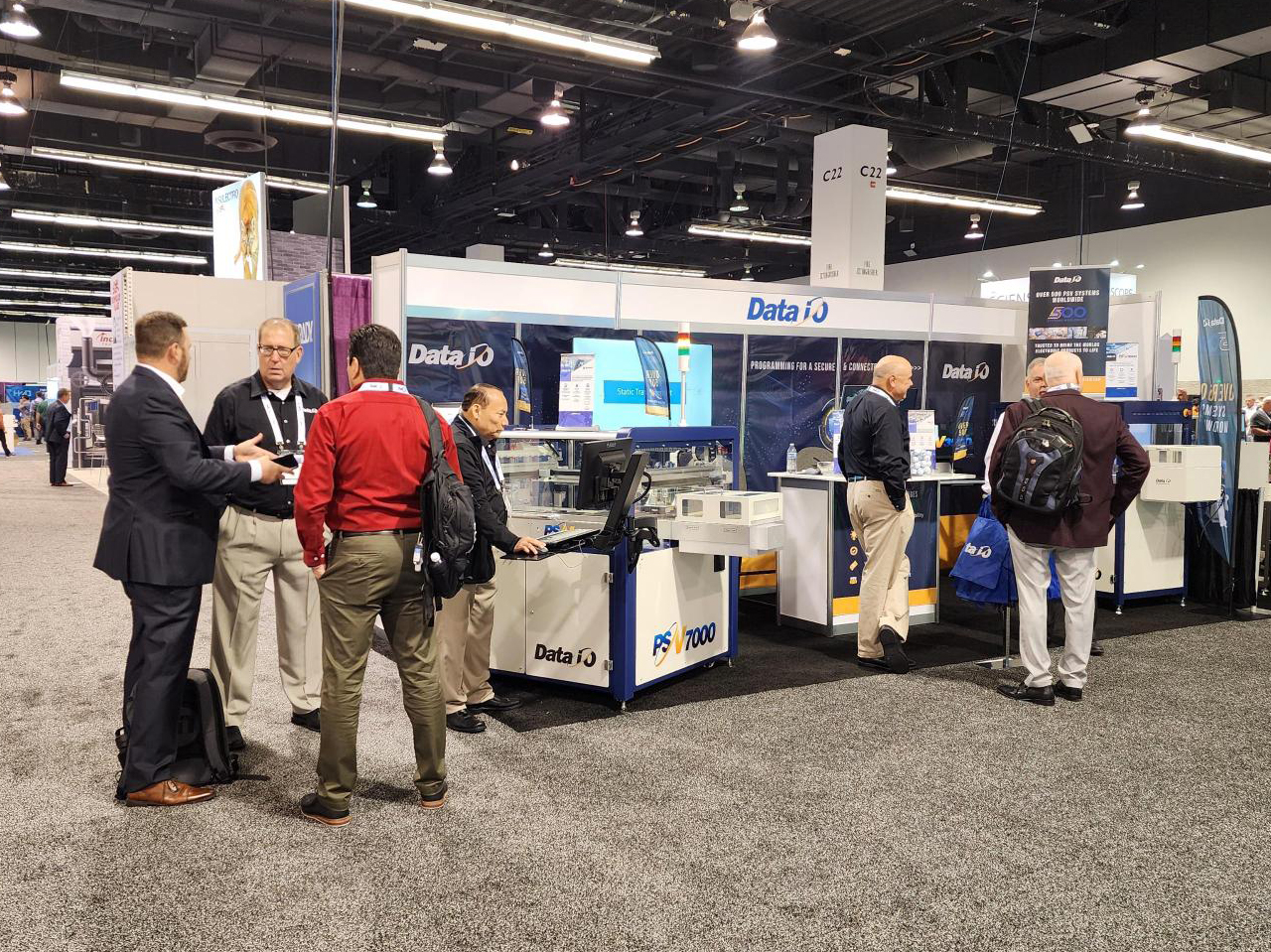 A group of professionals gather around a booth at a tradeshow
